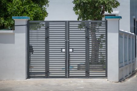 Modern panel house gate in gray color. The entrance gate of the house. Metal horizontal design gate for the house. Iron entrance gate.